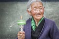 Unidentified elderly Tibetan woman in the Mindroling Monastery praying with prayer wheels - Zhanang County, Shannan Prefecture, Ti Royalty Free Stock Photo