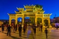 ZHANGYE, CHINA - AUGUST 22, 2018: Evening view of people practicing tai chi in front of a decorative arch in Zhangye