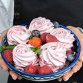 Zhenschina holds a Plate with homemade marshmallows, decorated with berries. No face. Bakery advertising concept, cooking secrets