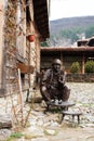 Zheravna, Bulgaria Mart 13, 2016: Bronze sculpture, statue of a man sitting on a chair and drinking coffee