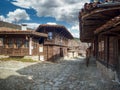 Zheravna, Bulgaria - narrow cobbled road and rustic traditional houses made of stone and wood with bigroot cranesbill Royalty Free Stock Photo