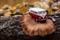 Zhmerynka, Ukraine - October 31, 2020: Toy retro bus Volkswagen Transporter T1 is located on a mushroom that grows on a log, white Royalty Free Stock Photo