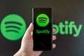 hand holding a mobile with spotify logo at horizontal composition