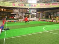 Boys playing soccer inside a shopping mall in a indoor soccer field.