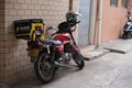 Motobike with Meituan food delivery case parking on the street