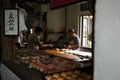 ZHOUZHUANG, CHINA: A food store in traditional cultural styling selling local handmade pastry. Women are in the middle of making h