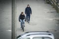 Zhytomyr, Ukraine - October 19, 2015: Young man wheeling bike in city near walking man