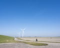 man on bicycle and wind turbines in rural landscape of schouwen duiveland in dutch province of zeeland Royalty Free Stock Photo