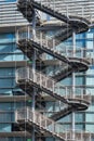 Zig zag iron stair for fire escape outside modern metal industrial building fence outdoor Royalty Free Stock Photo