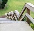 Zig-zag railings of wooden stairway on green grass background Royalty Free Stock Photo