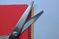 Zig Zag Scissors and examples of cloth pieces of red, dark red, gold Royalty Free Stock Photo