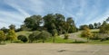 A zig-zag winding road going up a steep slope covered by lush vegetation under an amazing blue sky