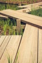 Zig-zag wooden pathway, footpath bridge over a lily pad filled water pond Royalty Free Stock Photo