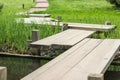 Zig-zag wooden pathway, footpath bridge over a lily pad filled water pond Royalty Free Stock Photo