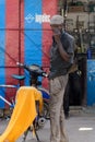 Unidentified Senegalese man stands near his motorcycle covered