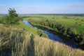 Zigzag river flows between summer valleys