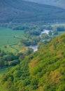 Zigzag river flows between summer valleys.Sunset river water natural landscape spring valley.