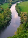 Zigzag river flows between summer valleys.Sunset river water natural landscape