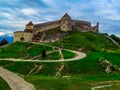 Zigzag road to the medieval Rasnov fortress in Romania. Beautiful landscape with an ancient fortification on a hill on a spring Royalty Free Stock Photo