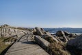 Zigzag wooden walkway in rocky coastline Royalty Free Stock Photo