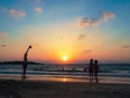 People actively spend time on the beach at sunset