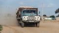 A ZIL car is driving and gathering dust along a dirt road in the village. Royalty Free Stock Photo