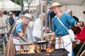 Zilina, Slovak RepubliÃÂ, Slovakia - July 28, 2023: Man woman preparing natural flatbread on fire during traditional annual