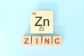 Zinc chemical element symbol with atomic mass and atomic number in wooden blocks flat lay composition.
