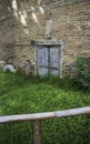 Zinc gate with old bricks wall and grass field Royalty Free Stock Photo