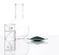 Zinc Powder in Chemical Watch Glass place next to crystal clear liquid in Beaker and Flat Bottom Flask Borosilicate Glass. Close