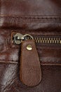 Zip fastener on a brown leather surface close-up