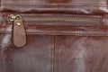 Zip fastener on a brown leather surface close-up