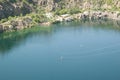 Zip line. Woman slides on a zipline over a radon lake. Trolley Track Over the lake. Ex-quarry flooded with water. Extreme and Royalty Free Stock Photo