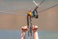 Zipline. Equipment for safe sliding on steel cable. Woman`s hands close-up during the flight