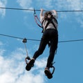 Zipline is an exciting adventure activity on background of blue sky in the clouds. Square picture.