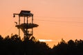 Zipline tower with people silhouettes at sunset