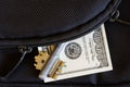 The zipper on the bag, unbuttoned by the thief, from whose pocket a hundred-dollar bill and key peeps. Social issues and crime Royalty Free Stock Photo