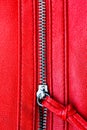 Zipper partly open close up detail macro photo on a red leather texture background in vertical format Royalty Free Stock Photo