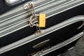 Zippers locked with a padlock on a black travel suitcase. Protect the baggage from theft during the trip. Luggage theft prevention