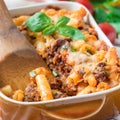 Ziti bolognese in baking dish, pasta casserole with minced meat, tomato sauce and cheese, square