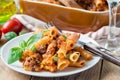 Ziti bolognese on white plate, pasta casserole with minced meat, tomato sauce and cheese, horizontal Royalty Free Stock Photo