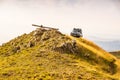 Zlatibor, Serbia - July 30, 2019. Vintage off road car on the top of the golden hill with lying cross on the top