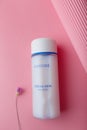 Zmail, Ukraine. March 2022. Laneige cream skin refiner bottle on pink background with flower. Korean face skin care cosmetics