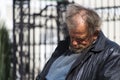 Zolochiv, Ukraine - April 10, 2018: Homeless tramp sitting asleep