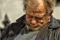 Zolochiv, Ukraine - April 10, 2018: Homeless tramp sitting asleep