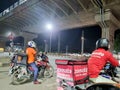 Zomato bike rider delivery boy looking at rider from swiggy food tech starup apps showing rivalry and switching between