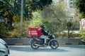 Zomato delivery boy with red hot box for food on a bike zooming at high speed to deliver orders for the upcoming Royalty Free Stock Photo