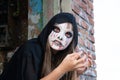 Zombie crawls out of the roof. Hands reach for the camera. Halloween and day of the dead concept. The red eyes of a vampire