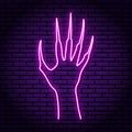 Zombie hand with claws, purple neon sign. Against the background of a brick wall.