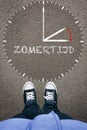 Zomertijd, Dutch Daylight Saving Time on asphalt with two shoes, high angle from above